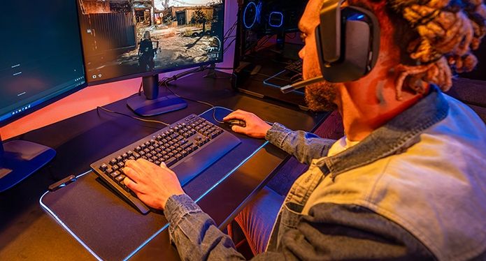 男子在雙顯示器上玩遊戲:一台用於遊戲,另一台用於 Discord 聊天